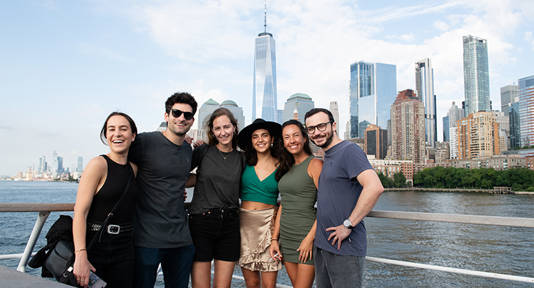 Group of students posed in front of city skyline including 1 World Trade Center