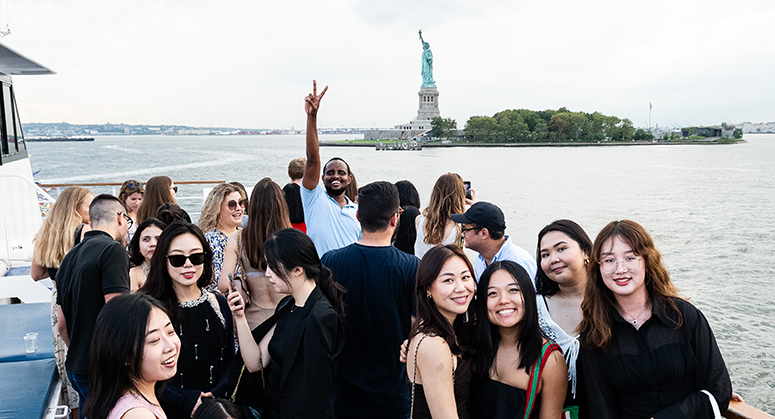 Candid photograph of group of students with Statue of Liberty in background