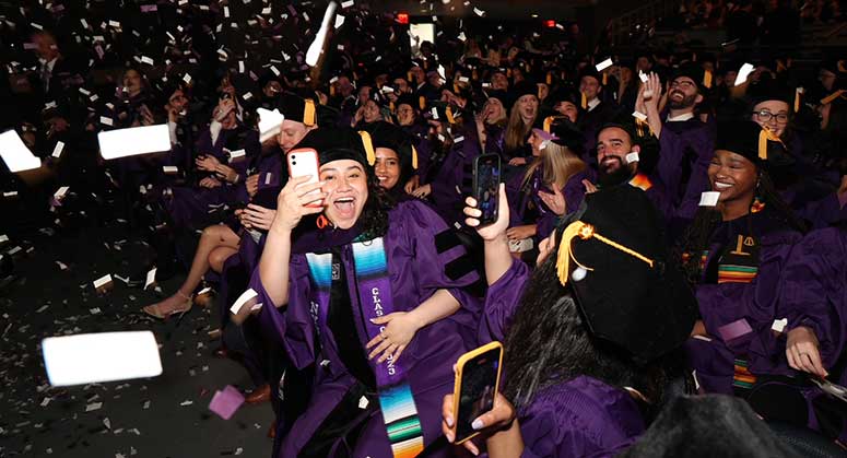 Excited graduate with phone at 2023 Convocation