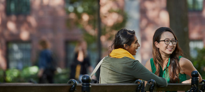 Two students on a bench in Washington Square Park