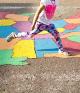 Girl stepping on map of USA painted on the ground