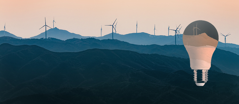 Hills with wind turbines against an orange sky.