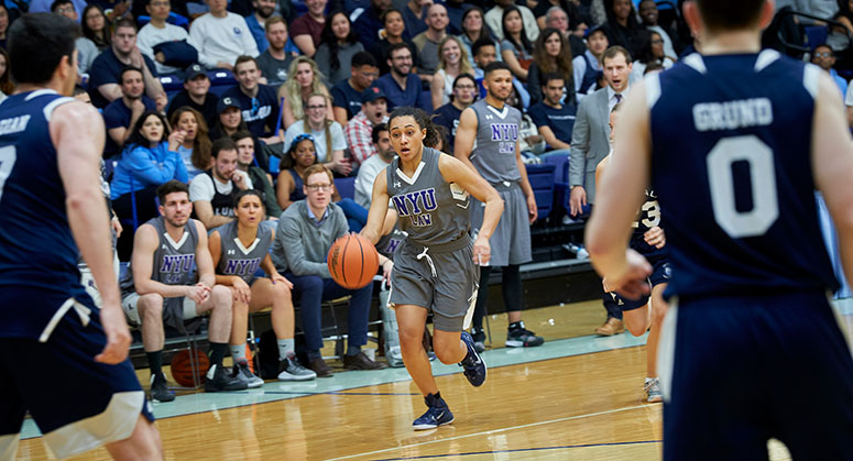 NYU Law student dribbling the basketball down the court during the 2019 Dean's Cup game