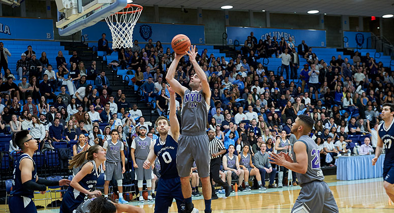 NYU Law student in the air dunking a basket