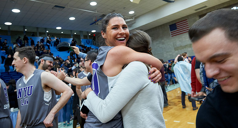 A member of the NYU Law Dean's Cup team hugging a friend after their win