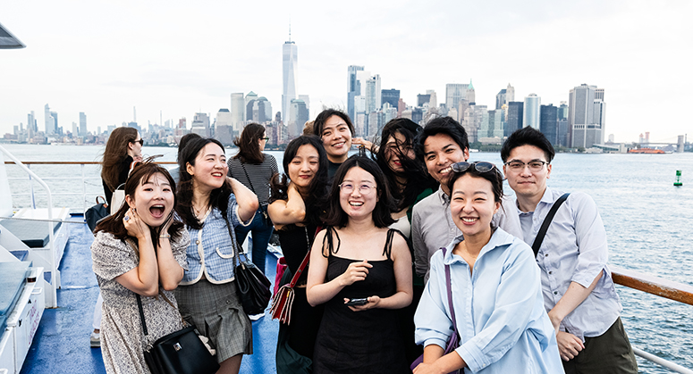 Group of students posed in front of city skyline
