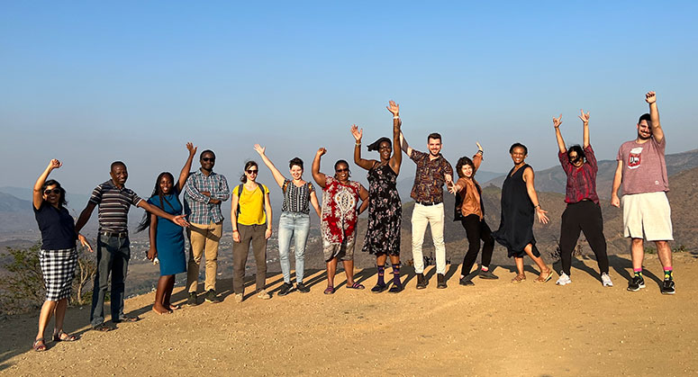 A group of 13 people jumping on a mountain top