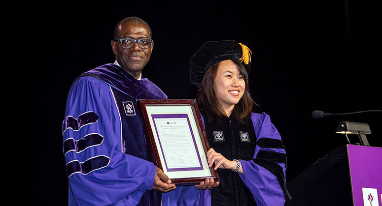 Anthony Welters receiving the class gift from graduating Law student, Alice Thai