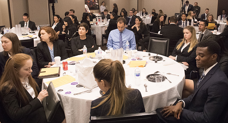 NYU Law students sitting around banquet tables, listening to the panelists at Early Interview Week
