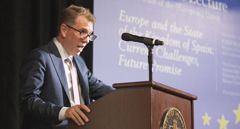 Trevor Morrison speaking behind a podium on an event about the European Union