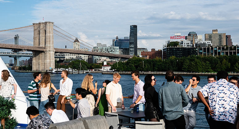 Students on a boat with Brooklyn Bridge in background