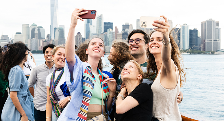 NYU Law students taking selfies during boat cruise