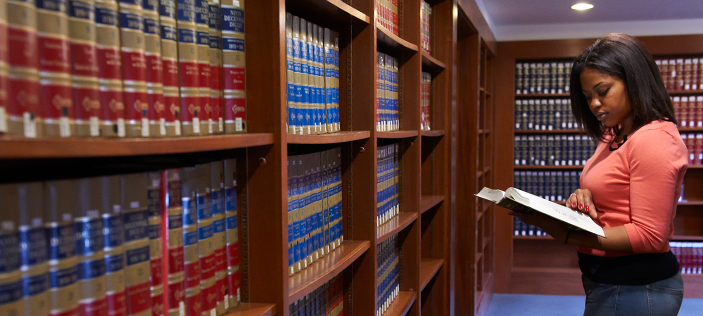 Student browsing amidst library stacks