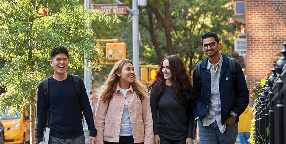 Students walking on sidewalk in front of Washington Square Park