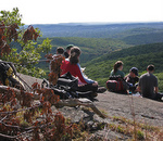 students sitting on rock bluff in Bear Mountain State Park