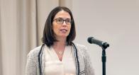 Lily Batchelder speaking at podium