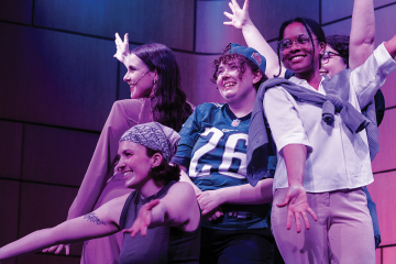 Group of students pose onstage