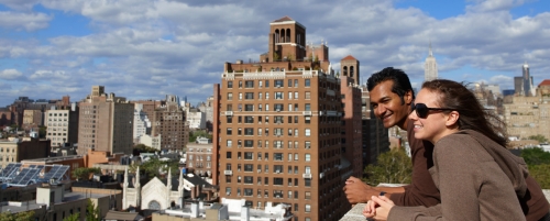 Two students looking at skyline from balcony