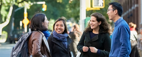 Four students chatting on street outside Vanderbilt Hall