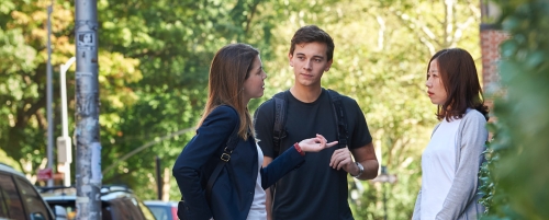 Three students talking on the street near Vanderbilt Hall