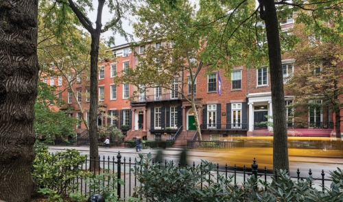 Cab driving by townhouses on Wasington Square North