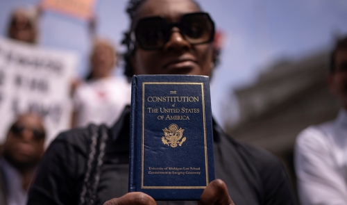 A person holding a copy of the Constitution of the United States of America.