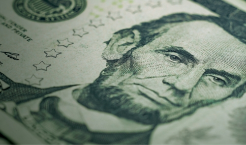 Angled close-up of Lincoln portrait on US five-dollar bill