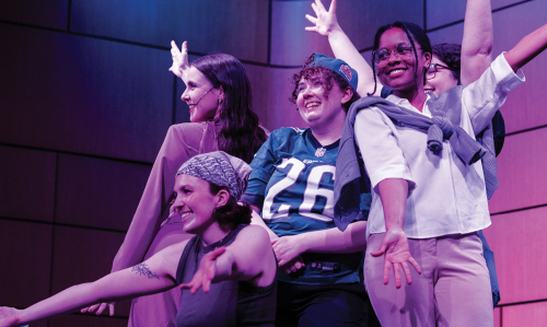 Group of students pose onstage