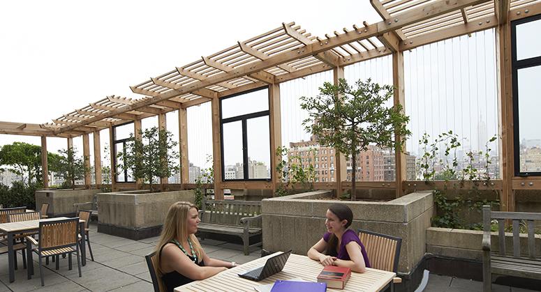 Students sitting at table on D'Agostino Hall terrace