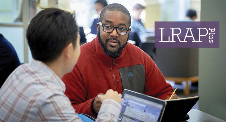 LRAP Plus: Two students chatting with computers open in student lounge