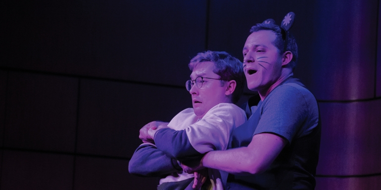 Two students singing on stage, one dressed as a rat, one as a chef