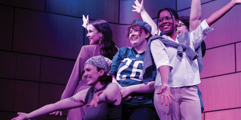 Group of students pose onstage