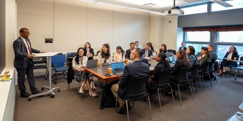 Professor teaching students at a seminar table