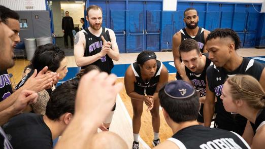 NYU Law players huddle in Dean's Cup game