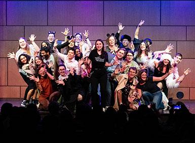 The full cast of Rata12b2ie on stage in a group