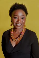 Black woman wearing necklace and earrings smiling 