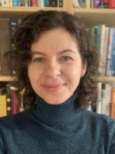 person with short curly hair smiling