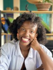 Black woman with short hair smiling at the camera