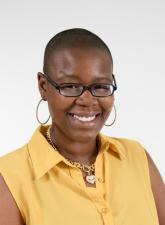 Photo of Jhody Polk smiling. Jhody is wearing a yellow shirt and glasses.