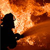 Silhouette of a firefighter battling a blaze.