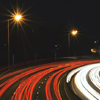 A long-exposure image of highway traffic at night.