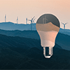 A lightbulb shape overlaid on top of hills with wind turbines against an orange sky.